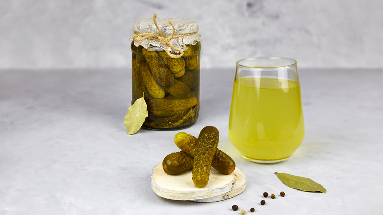 glass of pickle juice and pickles