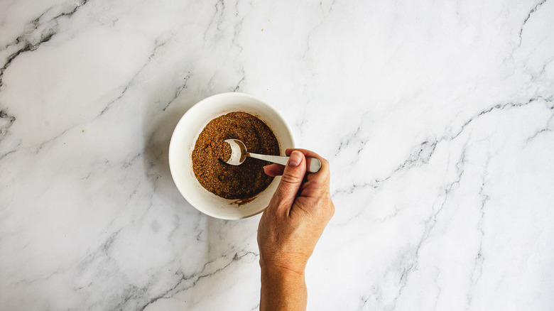 Mixing spice rub in white bowl with fork