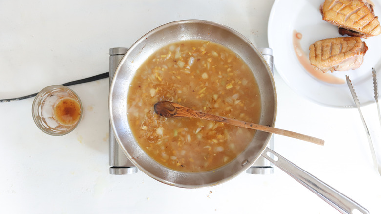 orange juice cooking with onions in a pan