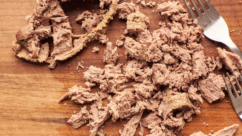 shredded duck on cutting board