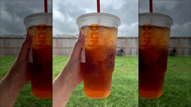 handheld Dunkin' iced tea outdoors