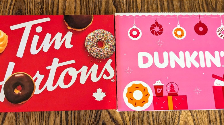 Close-up of red Tim Hortons donut box and pink, holiday-themed Dunkin' donut box