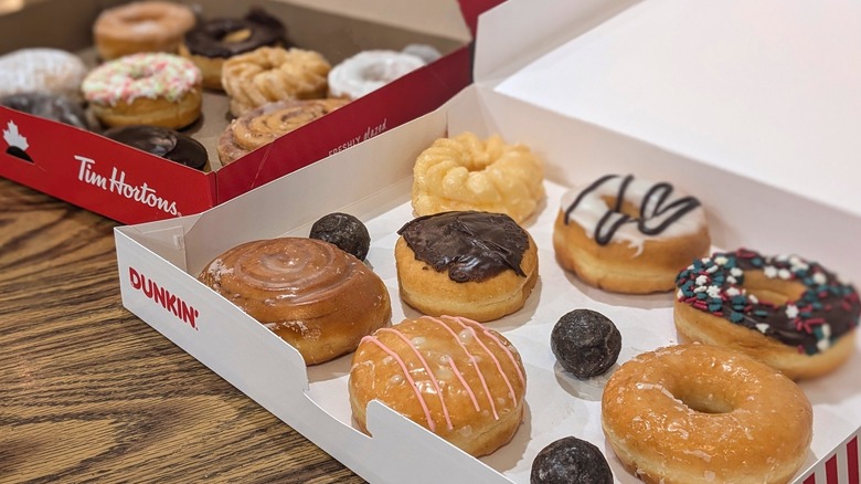 Dunkin' and Tim Hortons donut boxes open with assorted donuts inside