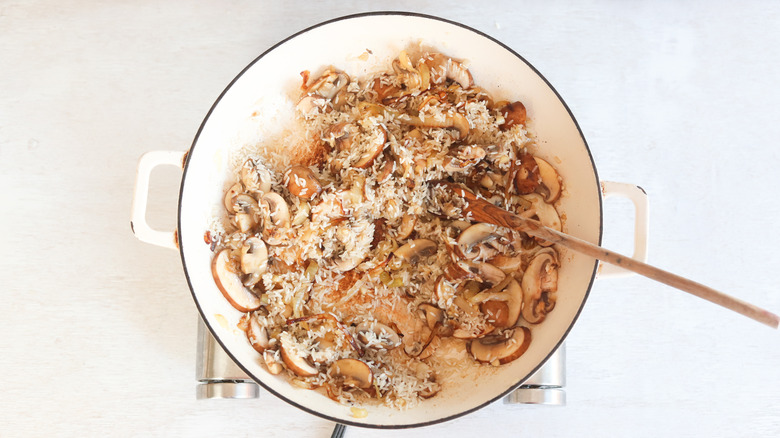 rice in a pan with mushrooms and onions