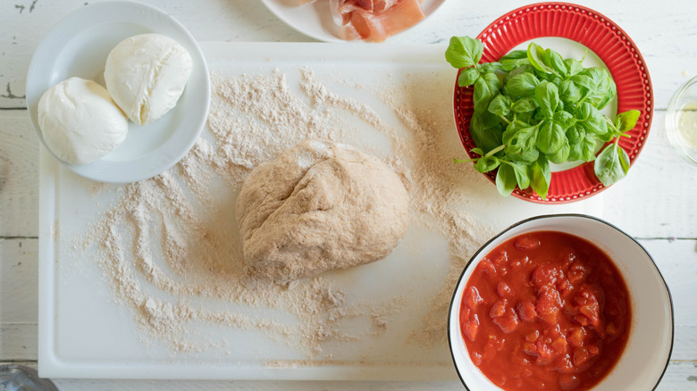 pizza dough surrounded by ingredients