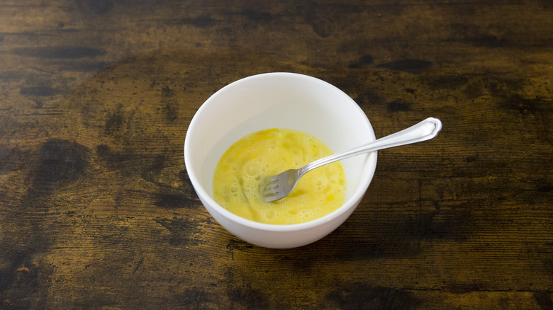 whisked eggs in white bowl 