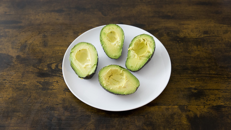 four avocado halves on plate 