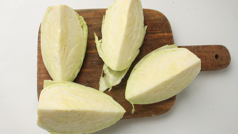 quartered cabbage on cutting board