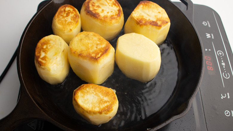 uncooked potatoes in skillet