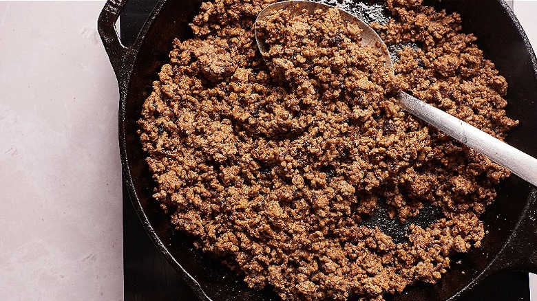 seasoning beef in skillet