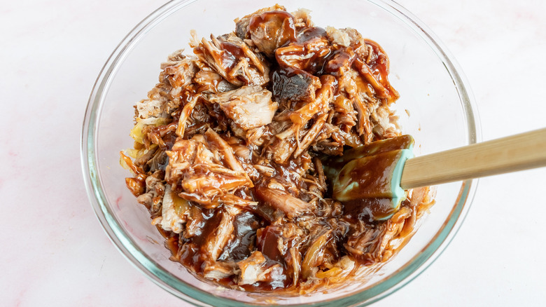 mixing pork and barbecue sauce together 