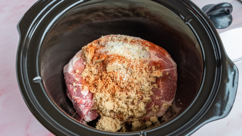 pork in crock pot with seasoning