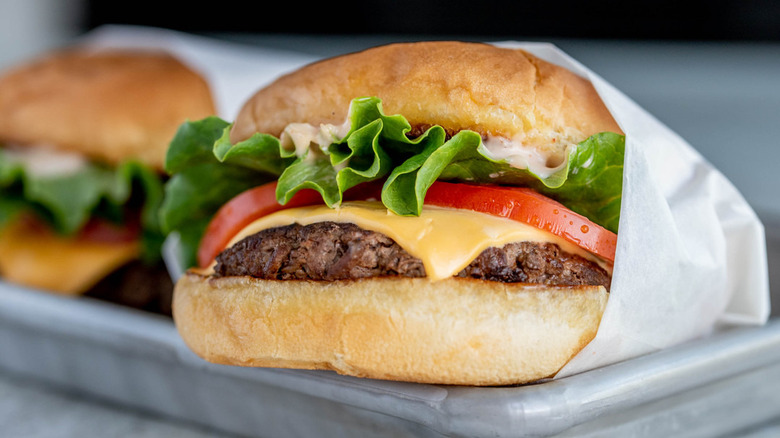 burger perched on metal tray