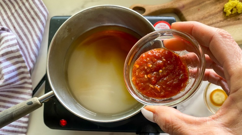 pouring sauce ingredients in pot