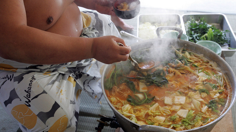 sumo wrestler serving soup