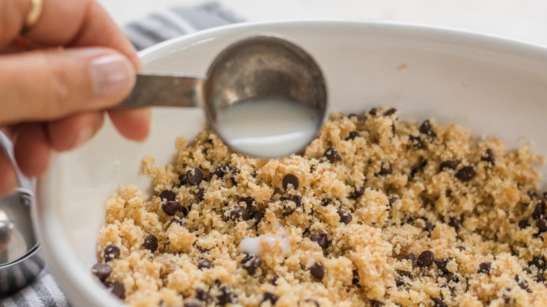 pouring milk into cookie dough