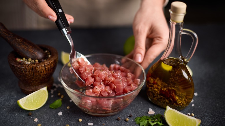 mixing raw tuna and olive oil