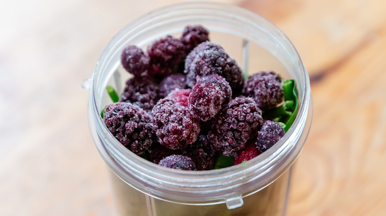 frozen berries and spinach in a bullet blender cup