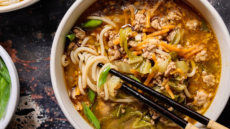 chopsticks grabbing noodles out of bowl