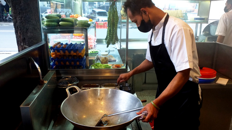 Chef heating oil in wok 