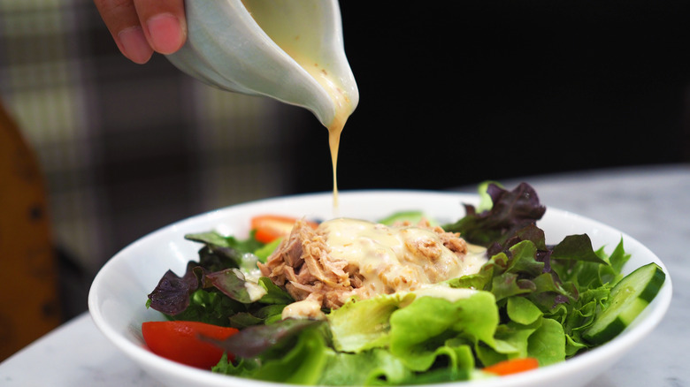 pouring dressing over salad 