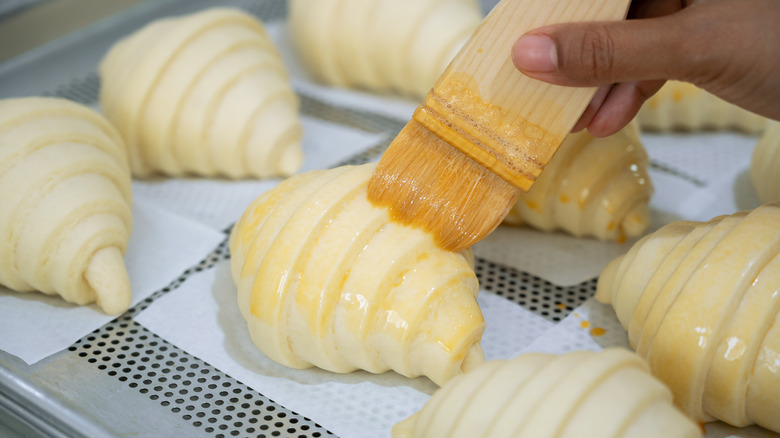 brushing croissants with egg wash