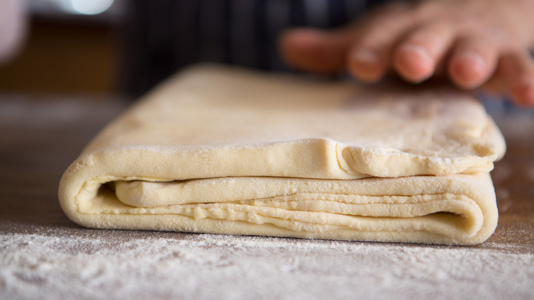 folded dough on floured board