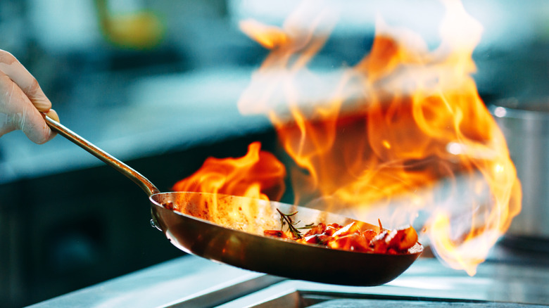 food being flambéed in pan