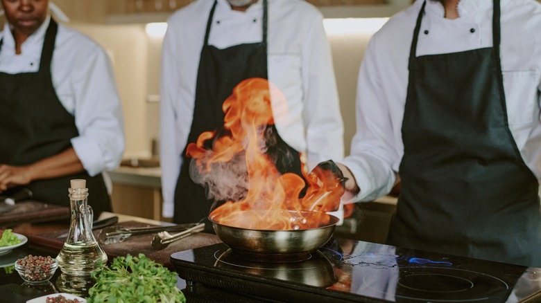 chef flambéing in pan