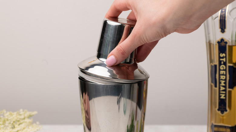 Placing lid on cocktail shaker 