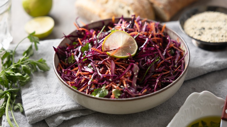 Bowl of Asian-style coleslaw with red cabbage, cilantro, and lime