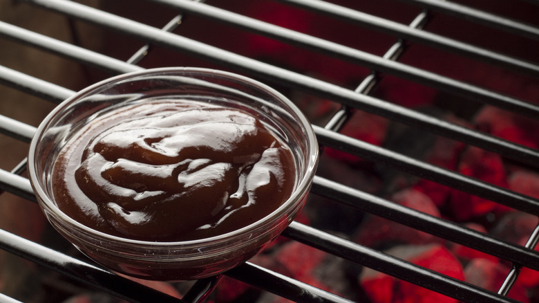 Bowl of BBQ sauce on grill