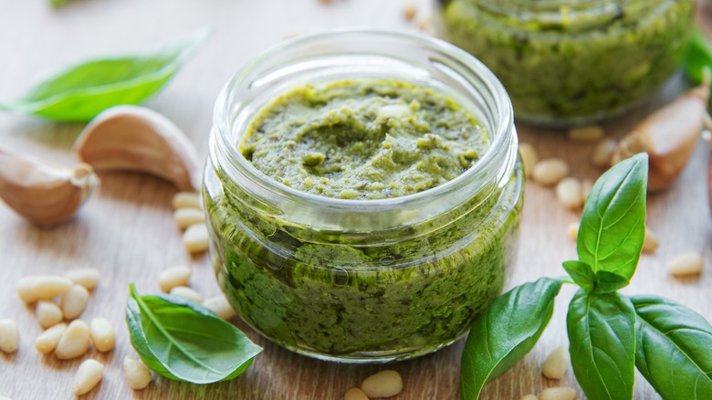 Jar of pesto next to ingredients