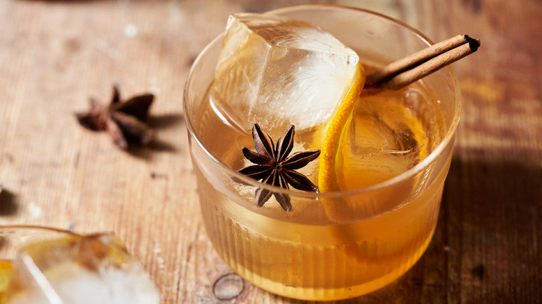 An old fashioned cocktail with ice, star anise, and cinnamon