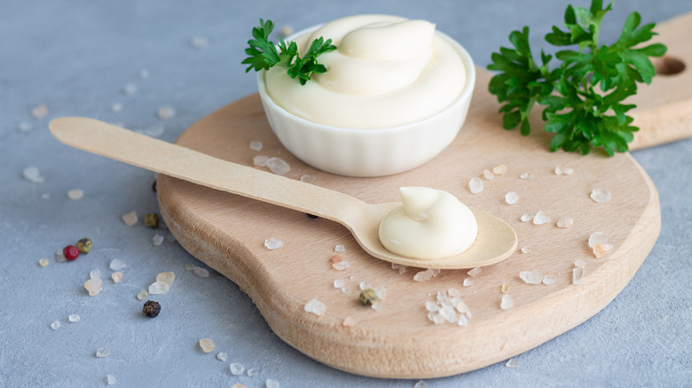 Small bowl of mayo with spoon.