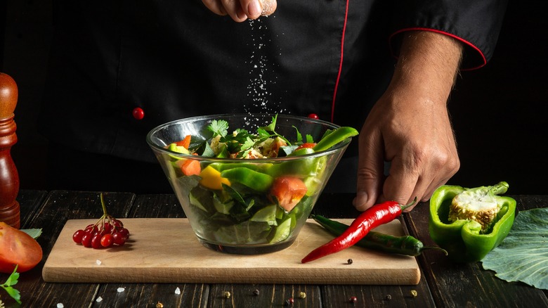 sprinkling salt on a salad