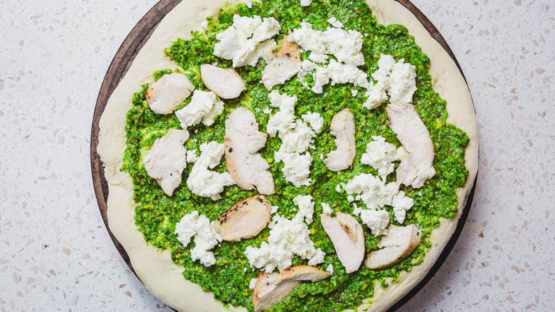 Unbaked pizza with ricotta and chicken