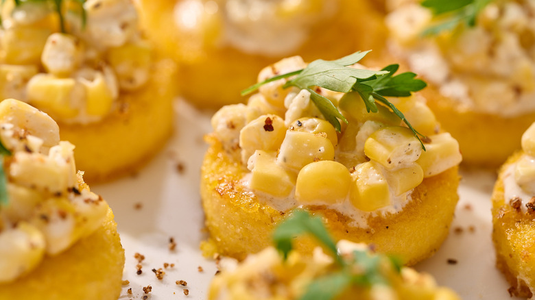 elote-topped polenta cakes on plate