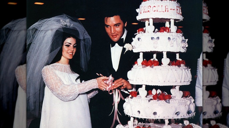 Elvis and Priscilla Presley with wedding cake