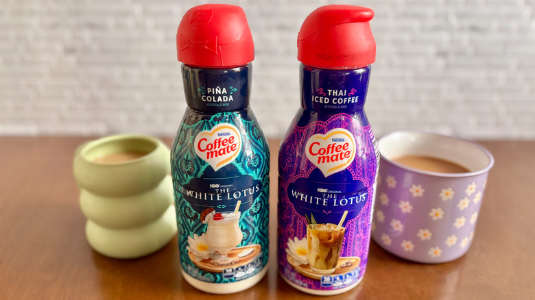 Two bottles of Coffee Mate creamer with two cups of coffee