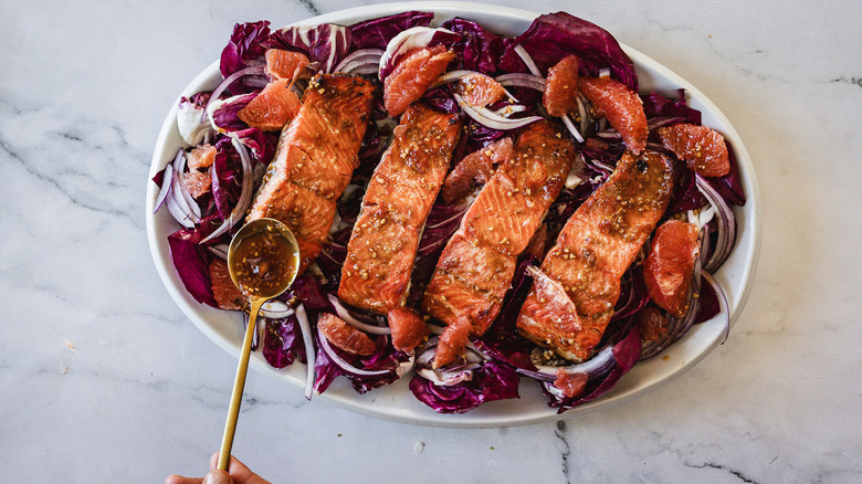 Pouring sauce on salmon salad