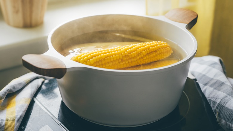 soaking corn on the cob in a bowl of water