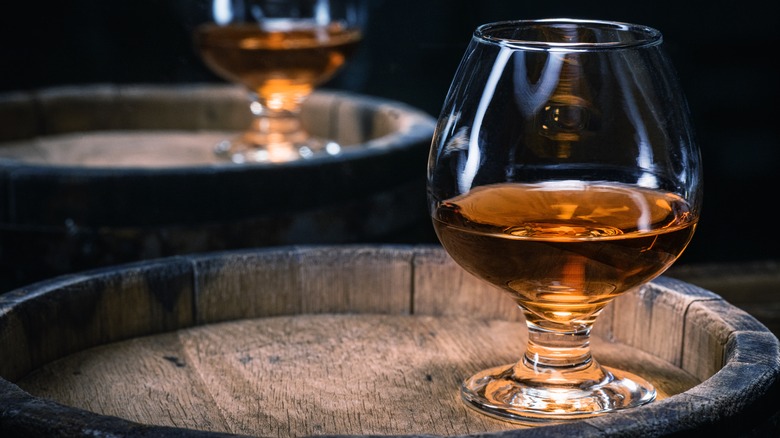 Glass of brandy on barrel