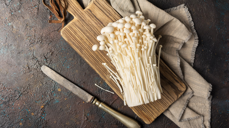 enoki mushrooms on cutting board