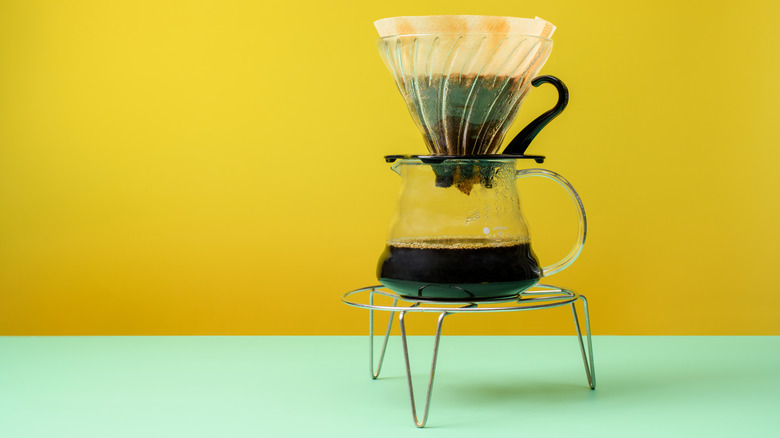 pour over style coffee set up on blue and yellow background