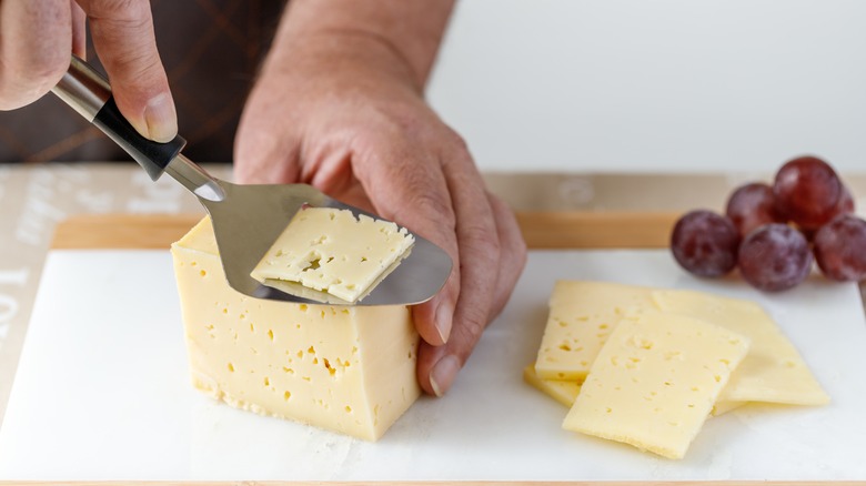 Cheese plane cutting cheese