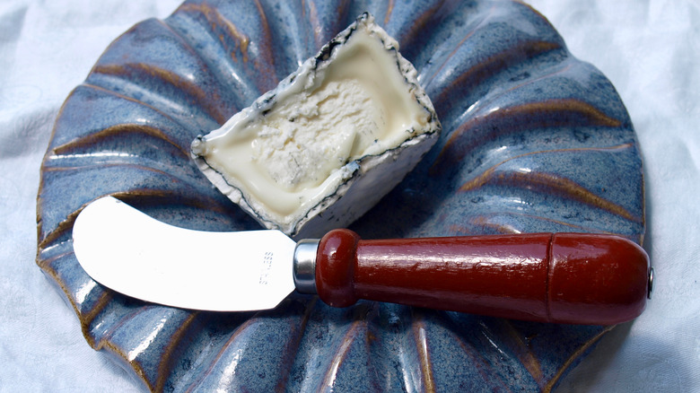 cheese spreader on a ceramic dish