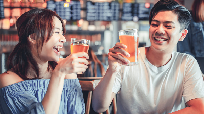 Two people sipping beer pint brewery