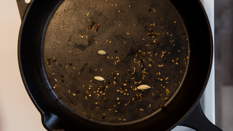 whole spices toasting in pan 