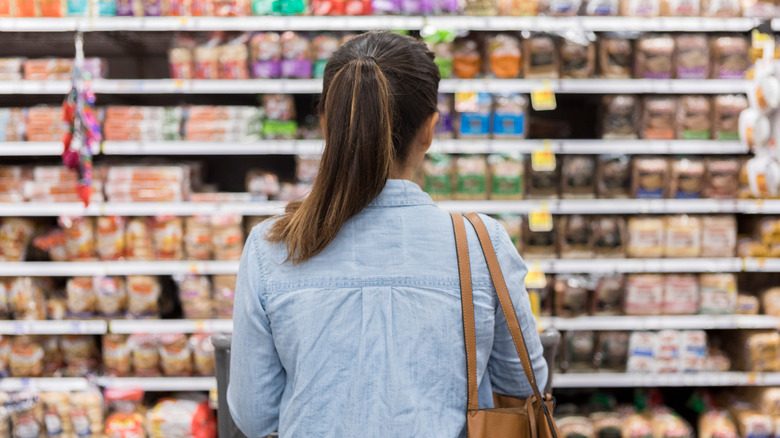 woman standing in supermarket aisle